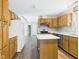 View of the kitchen featuring light wood cabinets, laminate countertops, stainless dishwasher, and a kitchen island at 3004 N Timber Ln, Muncie, IN 47304