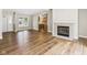 View of the living room featuring a fireplace, wood-look floors, neutral paint, and a bright window at 3004 N Timber Ln, Muncie, IN 47304