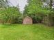 Backyard shed surrounded by greenery and trees, providing extra storage space and blending seamlessly with the landscape at 3004 N Timber Ln, Muncie, IN 47304