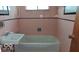Retro bathroom with pink tile and a combination tub and shower at 317 Grovewood Dr, Beech Grove, IN 46107