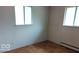 Well-lit bedroom featuring hardwood floors and two windows providing ample natural light at 317 Grovewood Dr, Beech Grove, IN 46107