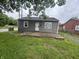 Cozy gray home with neat siding, trimmed windows, and a simple secure front entrance at 3202 N Emerson Ave, Indianapolis, IN 46218