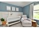 Cozy Bedroom featuring a white crib, plush recliner, neutral decor, and a soft, inviting atmosphere at 3872 New Battle Ln, Bargersville, IN 46106