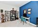 Bright home office featuring blue accent wall, desk, shelves and grey carpet at 3872 New Battle Ln, Bargersville, IN 46106