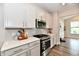 Well-lit kitchen with stainless steel appliances and white cabinets, perfect for cooking at 3872 New Battle Ln, Bargersville, IN 46106