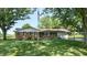 Charming brick home with well-manicured lawn, mature trees, and an American flag at 4124 Five Points Rd, Indianapolis, IN 46239
