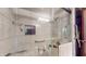 Tiled shower with glass door, grab bars, and wall niche at 4124 Five Points Rd, Indianapolis, IN 46239