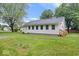 A well-maintained home with a white exterior, green lawn, and mature trees offers classic appeal at 4255 N County Road 1025 E, Indianapolis, IN 46234