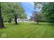 A charming home features a lush green lawn, mature trees, and a well-maintained exterior at 4255 N County Road 1025 E, Indianapolis, IN 46234