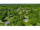 Expansive aerial shot showing homes surrounded by dense trees, showcasing a tranquil and private residential community at 4275 Springwood Trl, Indianapolis, IN 46228