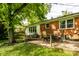 Backyard featuring a patio with table and chairs, brick house, trees and green lawn at 4275 Springwood Trl, Indianapolis, IN 46228