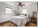 Bedroom featuring hardwood floors, two windows, ceiling fan and matching nightstands with lamps at 4275 Springwood Trl, Indianapolis, IN 46228
