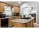 Functional kitchen featuring light wood cabinets, black appliances, and an island with a smooth cooktop at 4275 Springwood Trl, Indianapolis, IN 46228
