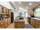 Spacious kitchen with an island cooktop, light wood cabinets, and views into the bright dining room at 4275 Springwood Trl, Indianapolis, IN 46228