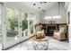 Bright sunroom with wicker furniture, a decorative fireplace, and large windows overlooking the lush greenery outside at 4275 Springwood Trl, Indianapolis, IN 46228