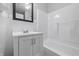 This bathroom features white tile, a dark framed mirror, and a shower and tub combination at 450 N Fenton Ave, Indianapolis, IN 46219