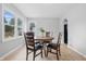 Bright dining room featuring a round wood table, seating for four, and a large window at 450 N Fenton Ave, Indianapolis, IN 46219