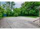 View of a concrete lot with lush greenery surrounding it at 4853 E 65Th St, Indianapolis, IN 46220