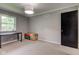 Bedroom featuring plush carpeting, natural light from a window, and a black door at 4853 E 65Th St, Indianapolis, IN 46220