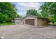Garage with a brown garage door, a concrete driveway, and greenery at 4853 E 65Th St, Indianapolis, IN 46220