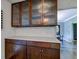 Kitchen area showcasing dark wood cabinets with glass fronts, complemented by white countertops and mosaic tile backsplash at 4853 E 65Th St, Indianapolis, IN 46220
