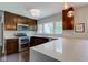 Modern kitchen featuring stainless steel appliances, dark wood cabinetry, and a large island with a white countertop at 4853 E 65Th St, Indianapolis, IN 46220