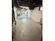Unfinished basement with painted concrete floor, painted cinder block wall, and access stairs at 5133 E Michigan St, Indianapolis, IN 46219