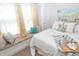 Bright bedroom featuring a window seat with pillows and a bed dressed in crisp white linens at 5133 E Michigan St, Indianapolis, IN 46219