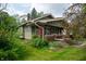 This lovely craftsman home features a brick foundation, green siding, and mature landscaping at 5133 E Michigan St, Indianapolis, IN 46219