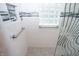 Contemporary shower featuring decorative tiles, grab bars, and clear glass, offering a modern and safe design at 5133 E Michigan St, Indianapolis, IN 46219