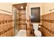 Tiled bathroom featuring a stand-up shower, brown-toned walls, and a sleek, modern toilet at 5153 Brendonshire Ct, Indianapolis, IN 46226