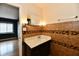 Bathroom with modern vanity, decorative mirror, and tiled walls extending into bedroom at 5153 Brendonshire Ct, Indianapolis, IN 46226