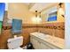 Bathroom featuring tiled wall, sink, lighting, and toilet at 5153 Brendonshire Ct, Indianapolis, IN 46226