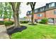 Well-maintained lawn with mature trees and landscaping complement the brick exterior of the townhomes at 5153 Brendonshire Ct, Indianapolis, IN 46226