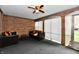 Cozy sunroom featuring exposed brick walls, neutral carpet, and ample natural light at 5153 Brendonshire Ct, Indianapolis, IN 46226