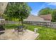 A backyard featuring a patio with dining set, mature tree, and a privacy fence at 5216 Lakeside Manor Blvd, Indianapolis, IN 46254