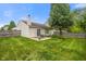 Spacious backyard featuring a patio with sliding glass door, mature trees, and privacy fence at 5216 Lakeside Manor Blvd, Indianapolis, IN 46254