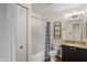 Well-lit bathroom with a shower-tub combo, storage shelves, and a granite vanity at 5216 Lakeside Manor Blvd, Indianapolis, IN 46254