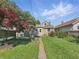 Landscaped backyard featuring a grassy yard, a path, mature trees, and the back of the home at 621 N Livingston Ave, Indianapolis, IN 46222