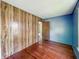 Bedroom features wood paneling, hardwood floors, and a blue accent wall at 621 N Livingston Ave, Indianapolis, IN 46222