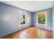 Cozy bedroom featuring hardwood floors, two windows, and neutral paint at 621 N Livingston Ave, Indianapolis, IN 46222