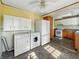 Cozy kitchen with laundry area, white appliances and tile flooring, ceiling fan and lighting at 621 N Livingston Ave, Indianapolis, IN 46222