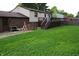 View of backyard with a large lawn and wooden deck attached to the house at 7402 Broadview Dr, Indianapolis, IN 46227