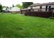 The property features a large backyard with an expansive grassy lawn and a wooden deck attached to house at 7402 Broadview Dr, Indianapolis, IN 46227