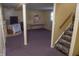 A partially finished basement featuring purple carpeting and stairs leading up to the main level at 7402 Broadview Dr, Indianapolis, IN 46227