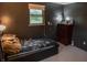 A cozy bedroom features a twin bed, dark walls, and natural light from a window, creating a relaxing ambiance at 7402 Broadview Dr, Indianapolis, IN 46227