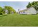 A spacious backyard showing ample green lawn with mature trees and storage sheds at 7418 Southern Lakes Dr, Indianapolis, IN 46237