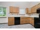 Eat-in kitchen featuring oak cabinets, window over sink and black appliances at 7418 Southern Lakes Dr, Indianapolis, IN 46237