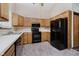 Kitchen with oak cabinets and black appliances at 7418 Southern Lakes Dr, Indianapolis, IN 46237