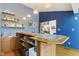 A stylish bar area with tile accents, shelving, a sink, and hardwood floors at 7426 Shadow Wood Dr, Indianapolis, IN 46254